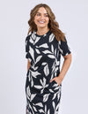 Woman wearing a black dress with white leaf pattern on a white background
Mimosa Tee Dress Black