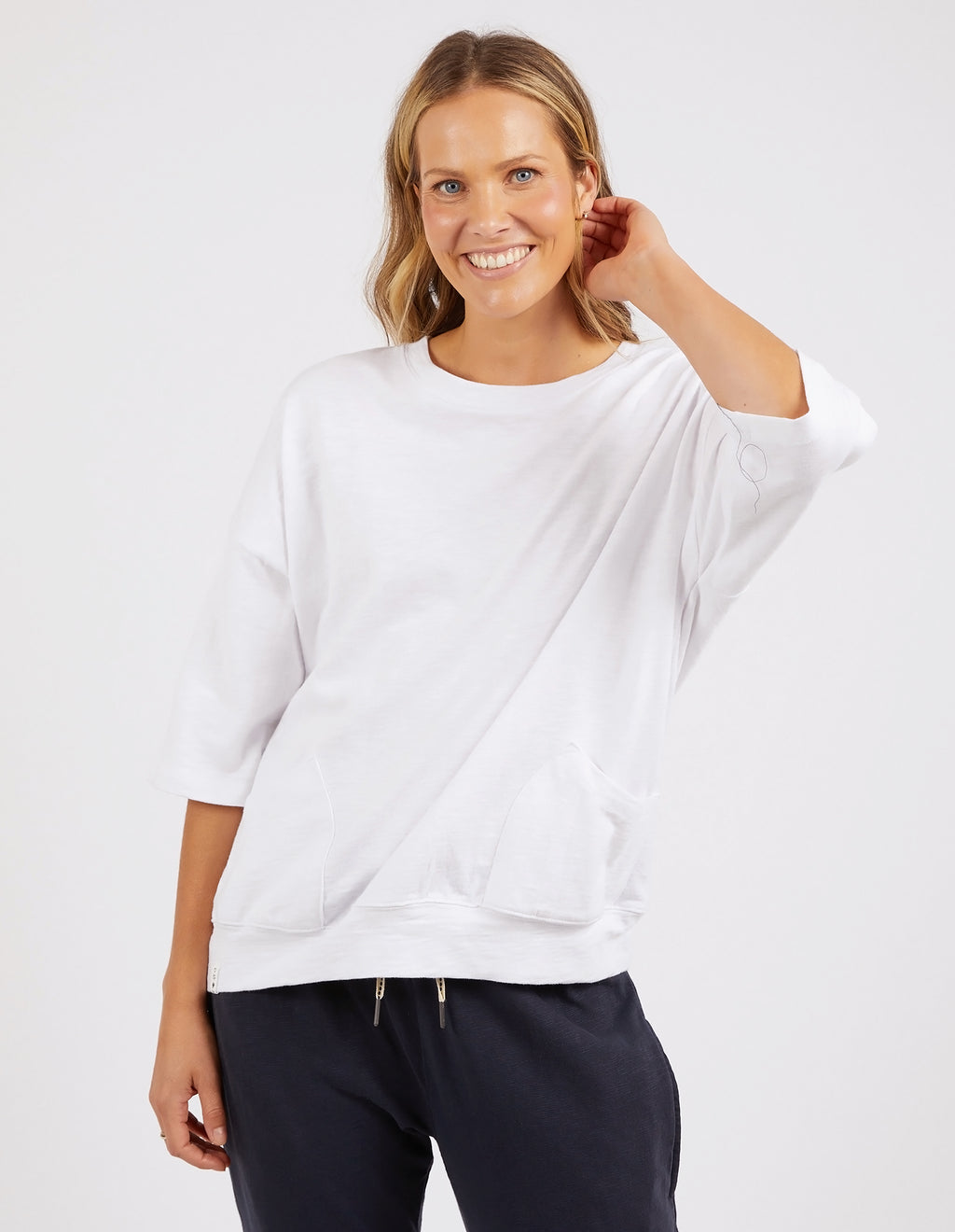 Woman wearing a white oversized sweater and dark pants on a white background
Mazie Sweat White