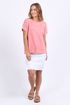 Woman wearing a pink top and white skirt on a white background
Allison Tee Rose