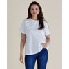 Woman wearing a white t-shirt with lace details and blue jeans on a beige background