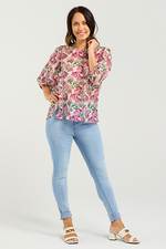 Woman wearing a floral blouse and light blue jeans on a white background
Ariel Top Rose Garden