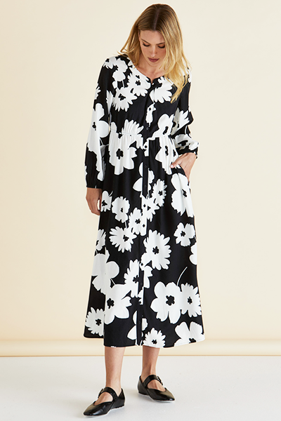 Woman wearing a black and white floral dress against a beige background
Aries Dress Floral