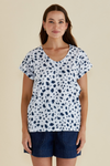 Woman wearing a white top with blue floral pattern and denim shorts on a beige background
Ayla V-Neck Tee Spot Print