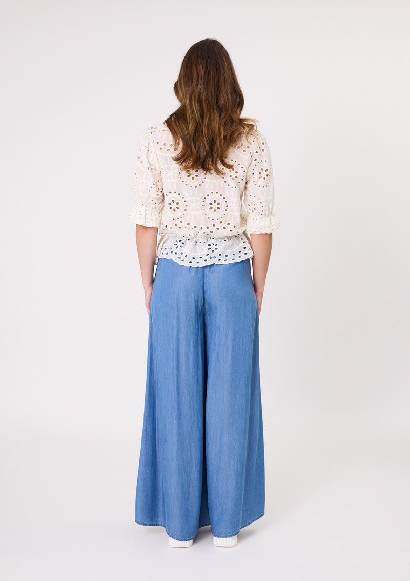Woman wearing a white lace top and blue wide-leg pants on a white background
Azzura Pant Chambray