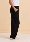 Person wearing black wide-leg pants and a white top against a beige 
Ginnie Bamboo Pant Blackbackground