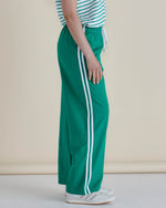 Green track pants with white stripes worn by a person on a beige background
Nikki Relax Cotton Jogger Green