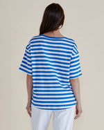 Person wearing a blue and white striped shirt against a plain background