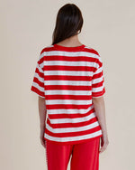 Person wearing a red and white striped shirt and red pants on a plain background