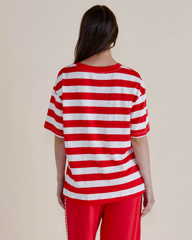Person wearing a red and white striped shirt and red pants on a plain background