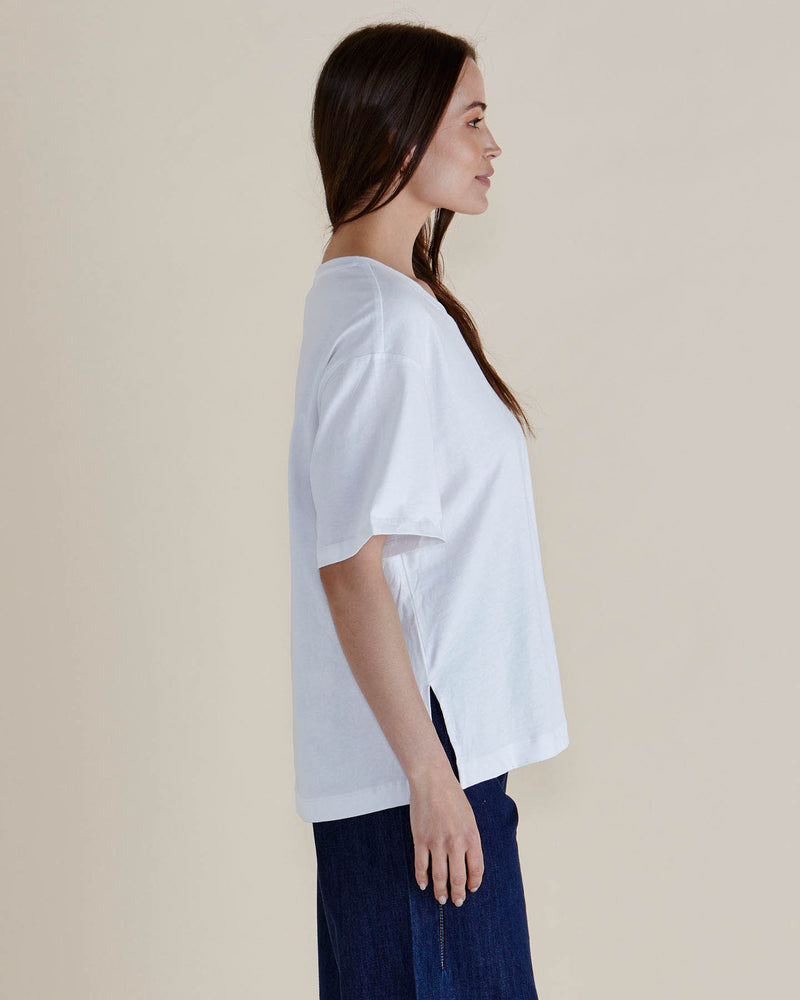 Woman wearing a white t-shirt and dark pants against a beige background
Relax Boxy Tee White