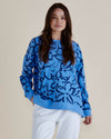 Woman wearing a blue patterned sweater against a beige background
Palma Sweat Blue Floral