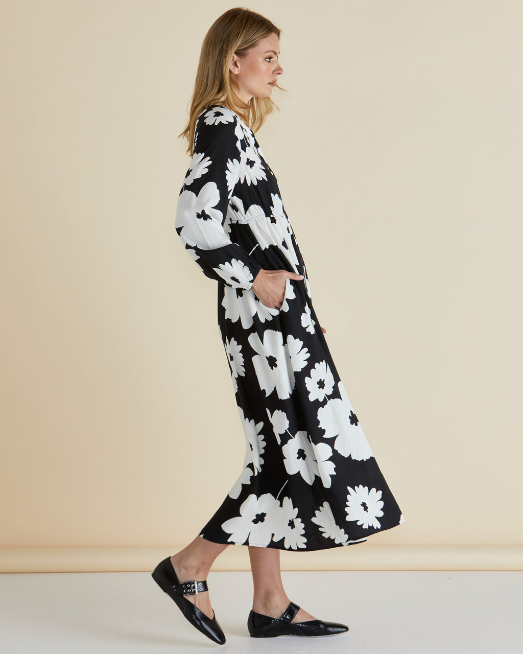 Woman wearing a black floral dress against a beige background
Aries Dress Floral
