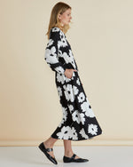 Woman wearing a black floral dress against a beige background
Aries Dress Floral