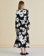 Woman wearing a black floral dress against a beige background
Aries Dress Floral