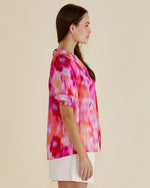 Woman wearing a colorful tie-dye shirt on a beige background Joanne Blouse Floral Pink