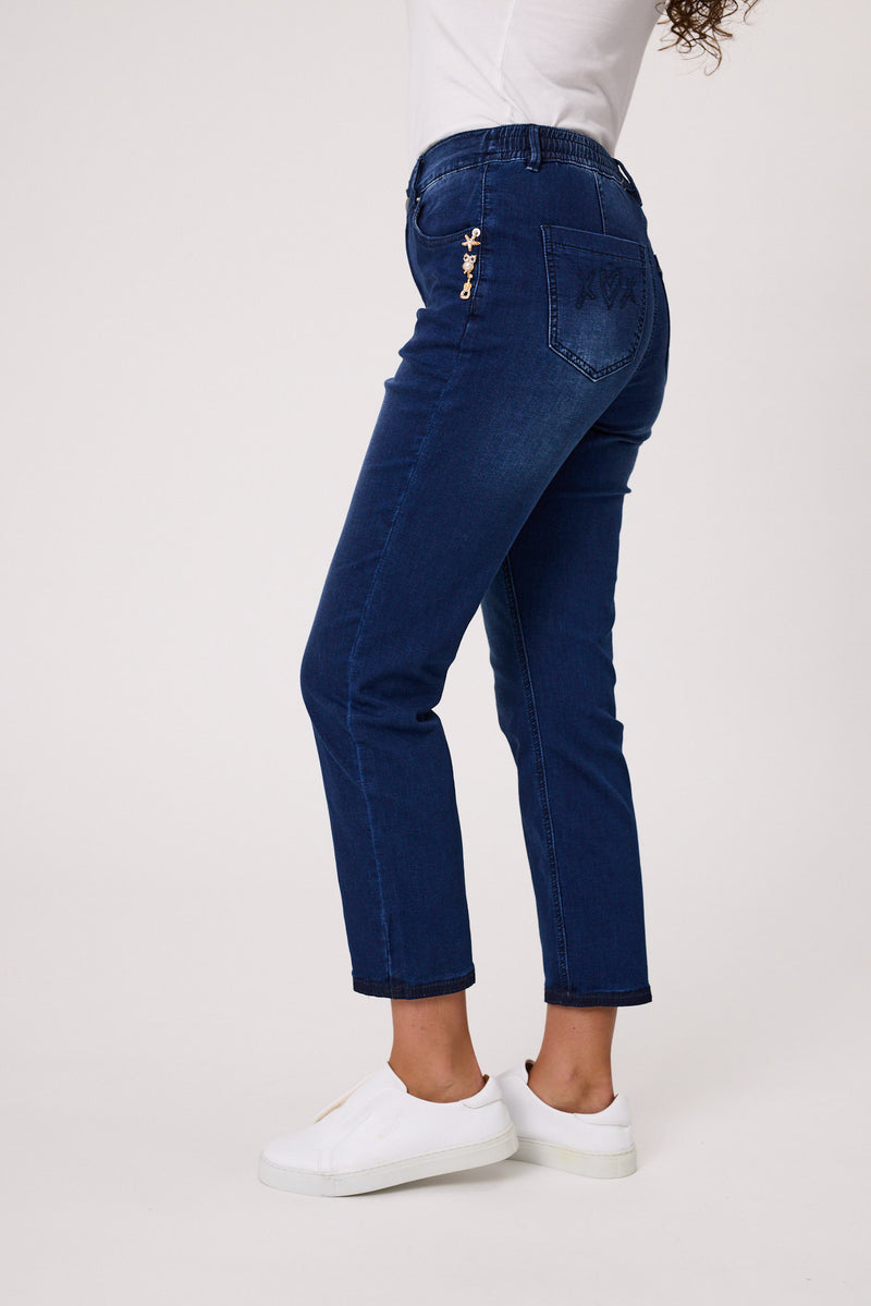 Person wearing blue jeans and white sneakers on a white background