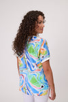 Woman wearing a colorful abstract patterned shirt on a plain background Life Top Green