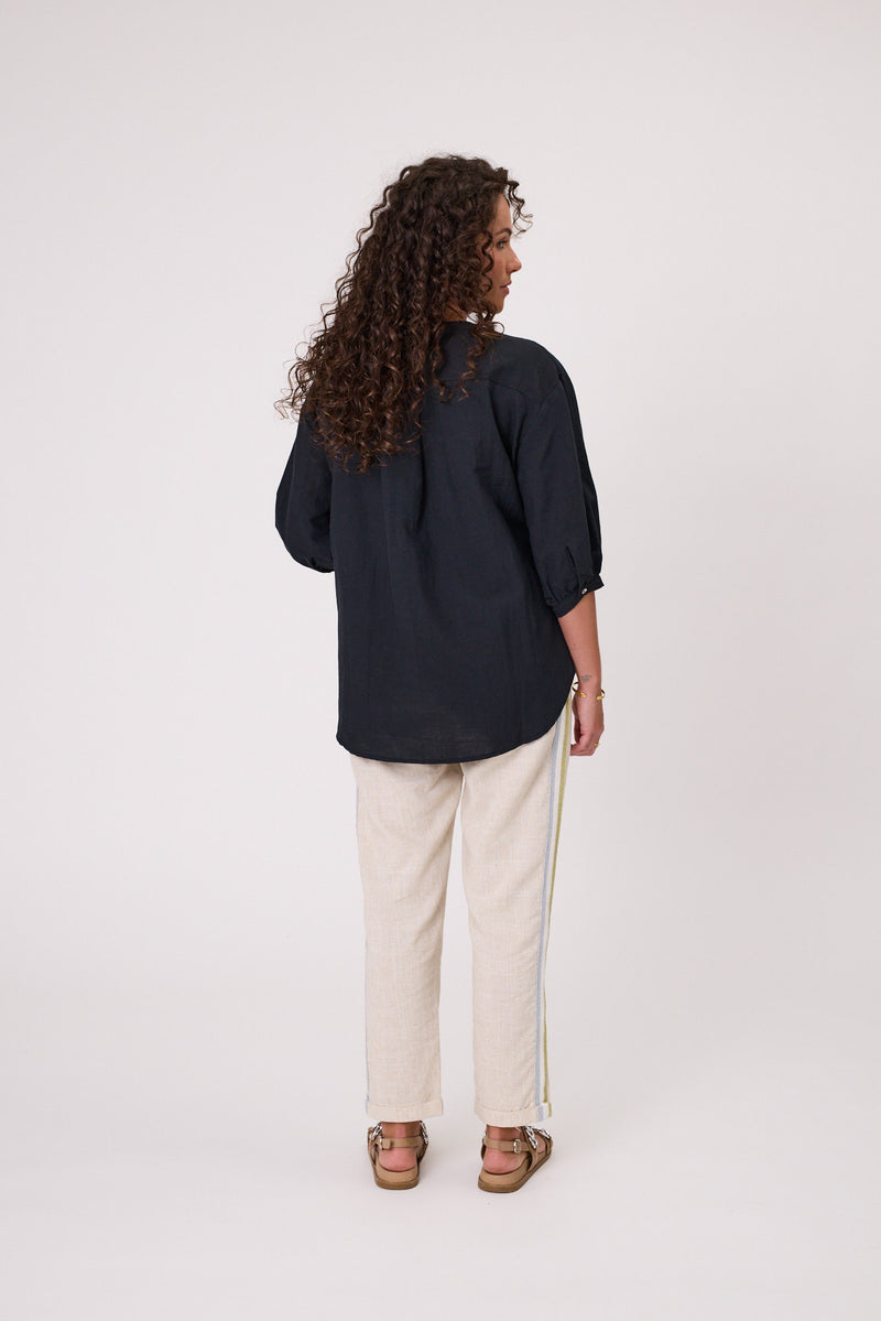 Woman wearing a black shirt and white pants on a white background Daisy Print Linen Top Black