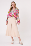 Woman wearing a colorful floral blouse and beige wide-leg pants on a white background
Contessa Top Garden Print