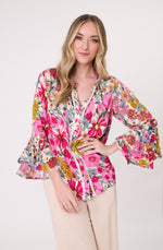 Woman wearing a colorful floral blouse with bell sleeves on a white background
Contessa Top Garden Print