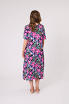 Woman wearing a colorful floral dress on a white background Ella Dress Navy