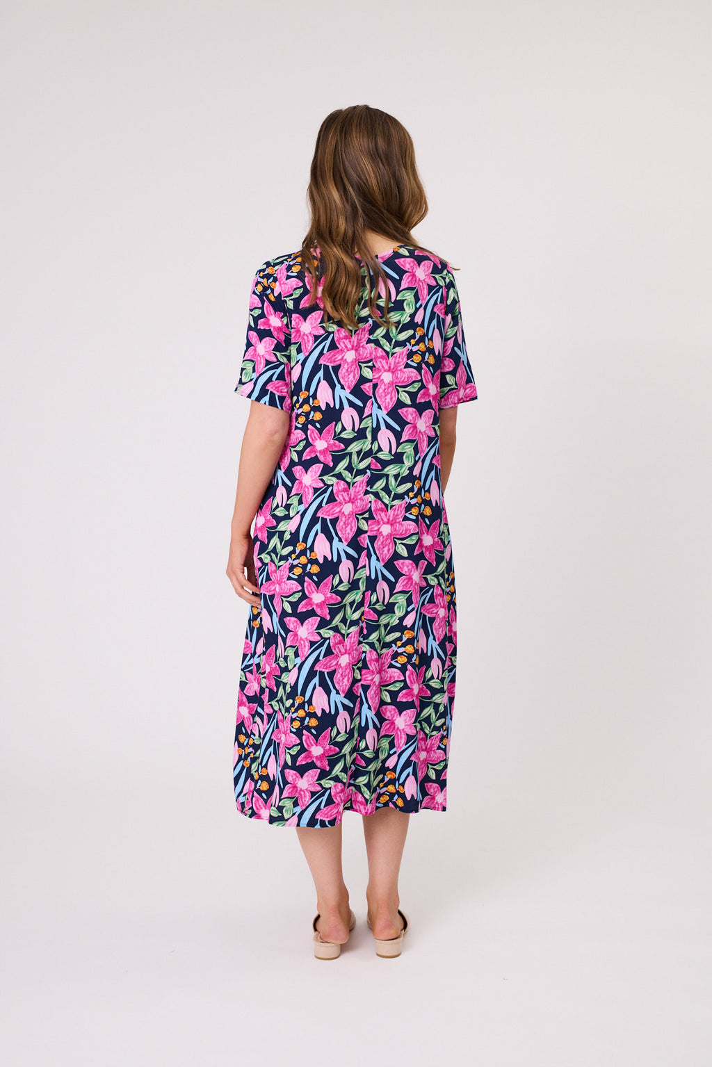Woman wearing a colorful floral dress on a white background Ella Dress Navy