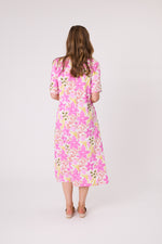 Woman wearing a pink floral dress on a white background Ella Dress White