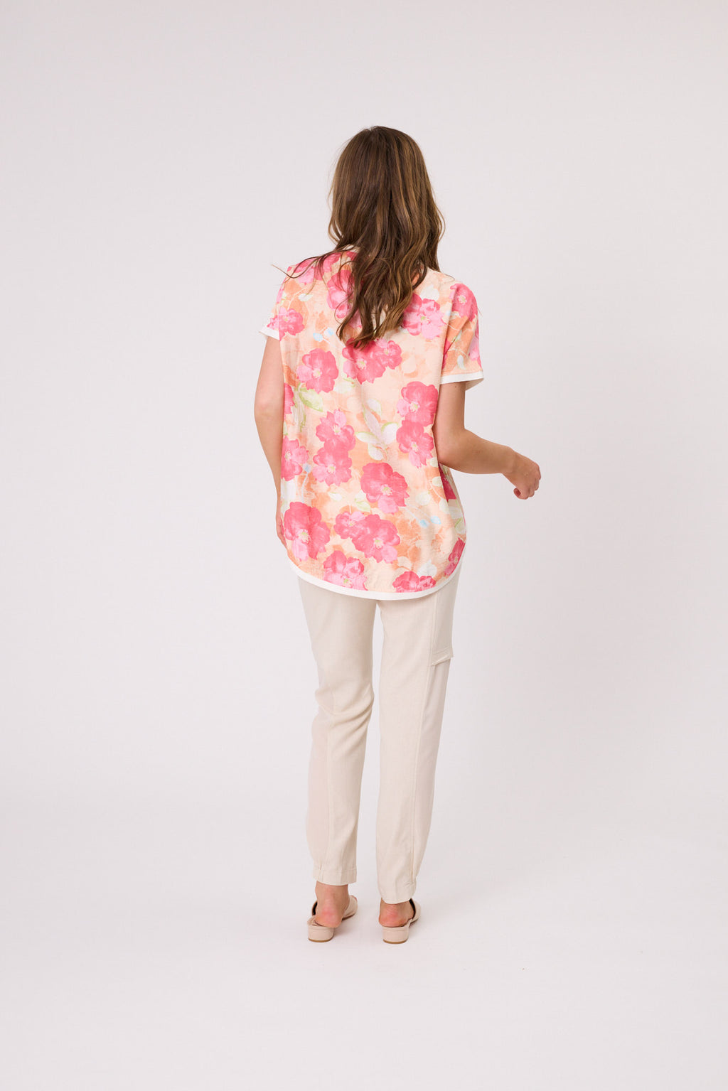 Woman wearing a floral blouse and beige pants on a white background Riley Print Top Coral