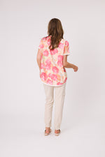 Woman wearing a floral blouse and beige pants on a white background Riley Print Top Coral