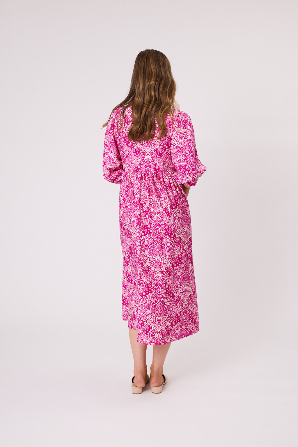 Woman wearing a pink floral dress on a white background Paisley Dress Hot Pink