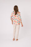 Woman wearing a floral blouse and beige pants on a white background Calli Top Pink