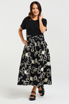 Woman wearing a black dress with white floral patterns on a white background
Delilah Dress Black Garden