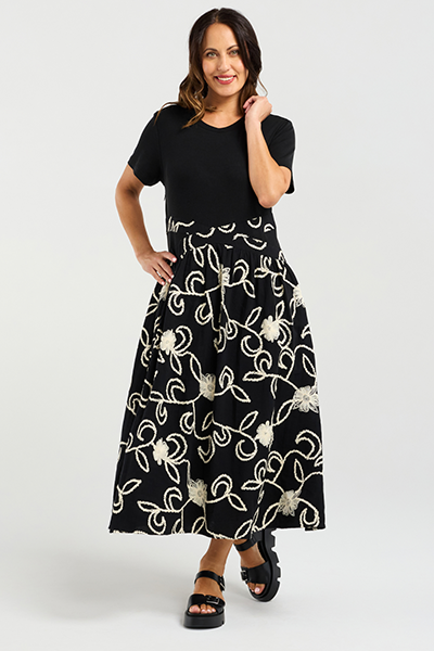 Woman wearing a black dress with white floral patterns on a white background
Delilah Dress Black Garden