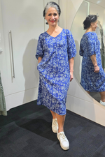 Woman wearing a blue floral dress standing in front of a mirror.
Elastic Sleeve Dress Blue