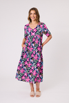 Woman wearing a colorful floral dress on a white background Ella Dress Navy