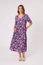 Woman wearing a colorful floral dress on a white background Ella Dress Navy