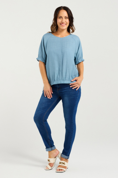 Woman wearing a blue top and jeans on a white background
Ella Top Blue