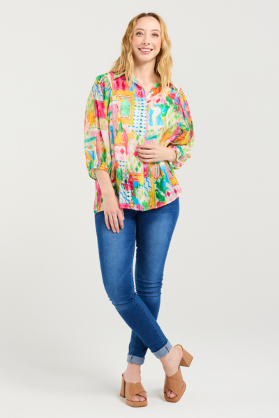 Woman wearing a colorful floral blouse and blue jeans on a white background
Emily Shirt Radiant