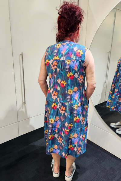 Person wearing a colorful floral dress in front of a mirror.
Everly Dress Navy