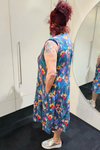 Person wearing a colorful floral dress in a bathroom setting
Everly Dress Navy