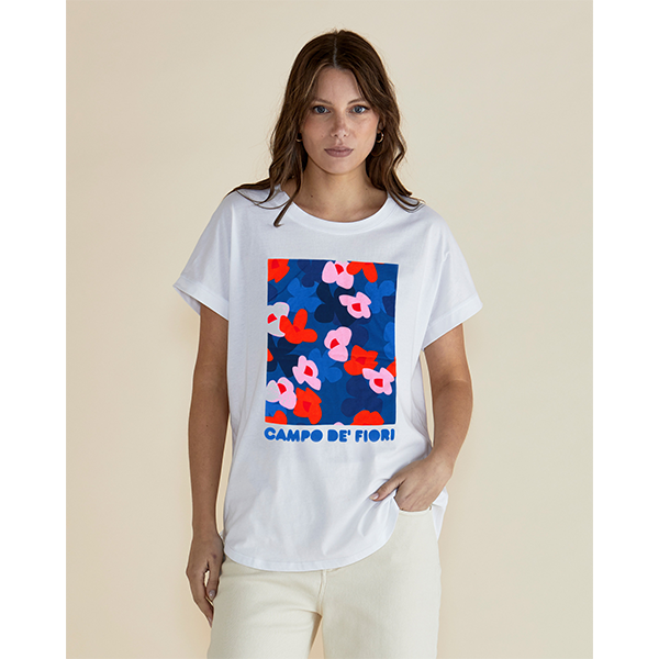 Woman wearing a white t-shirt with colorful floral design and 'Campo de Fiori' text on a beige background