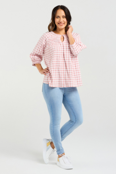 Woman wearing a pink checkered blouse and light blue jeans on a white background
Hazel Top Pink Check
