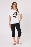 Woman wearing a white t-shirt with a black and yellow design and black pants on a white background In This Together T-Shirt White