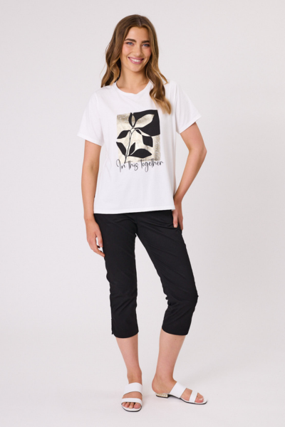 Woman wearing a white t-shirt with a black and yellow design and black pants on a white background In This Together T-Shirt White