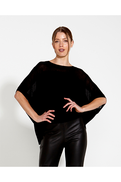 Woman wearing a black poncho and black pants on a white background
Irises Knit Black