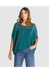 Woman wearing a teal oversized shirt and blue jeans on a white background
Irises Knit Teal