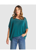 Woman wearing a teal oversized shirt and blue jeans on a white background
Irises Knit Teal