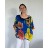 Woman wearing a colorful floral blouse against a plain background
