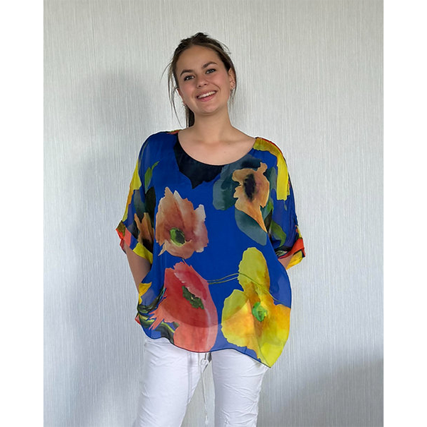 Woman wearing a colorful floral blouse against a plain background
