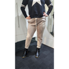 Person wearing a navy sweater with white star design and beige pants with mesh panels in a bathroom.